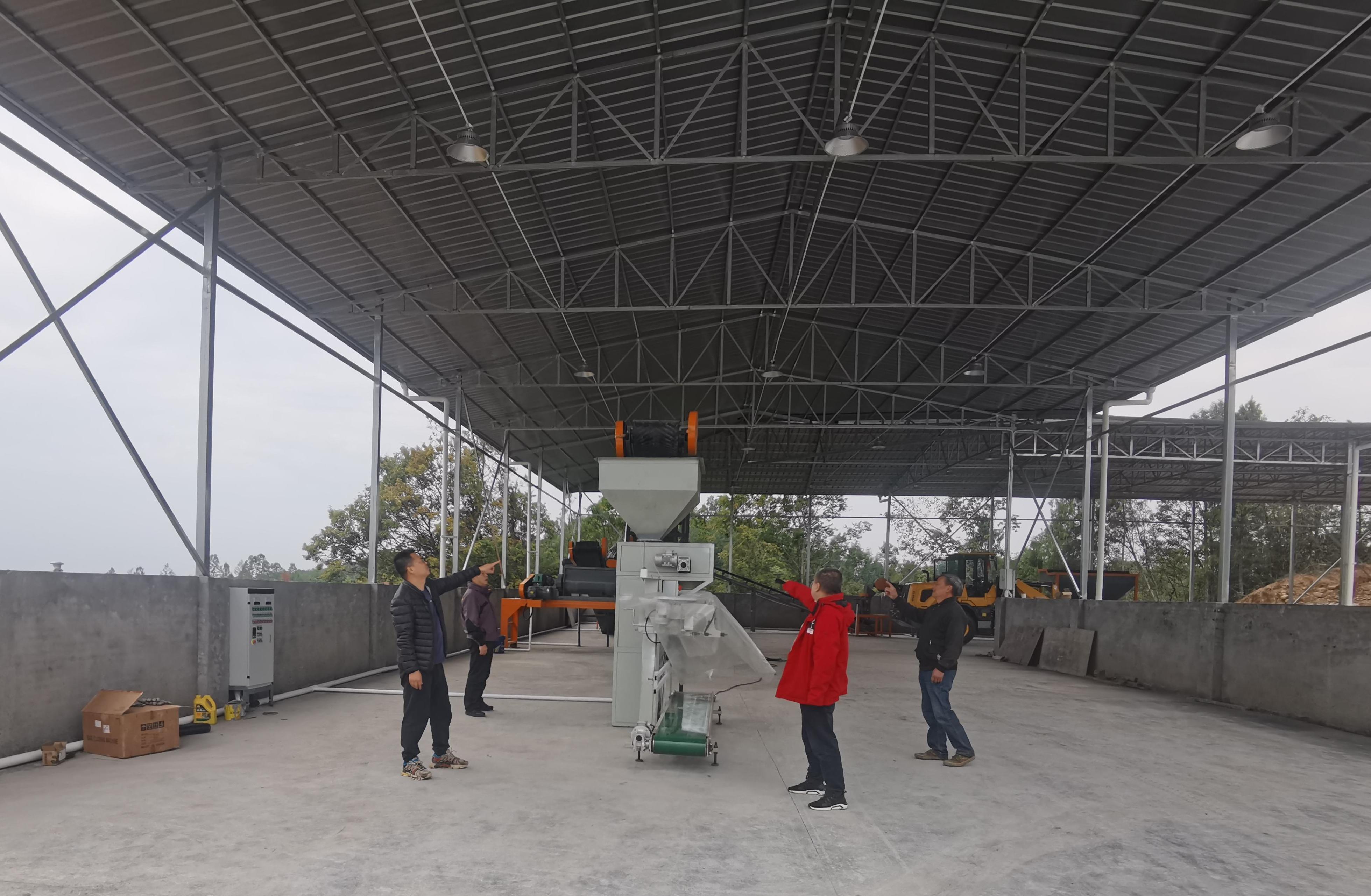 李杰超（左一）與村社干部、駐村隊員查看有機肥廠設(shè)備采購情況